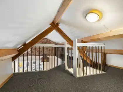 A loft with a staircase and a balcony