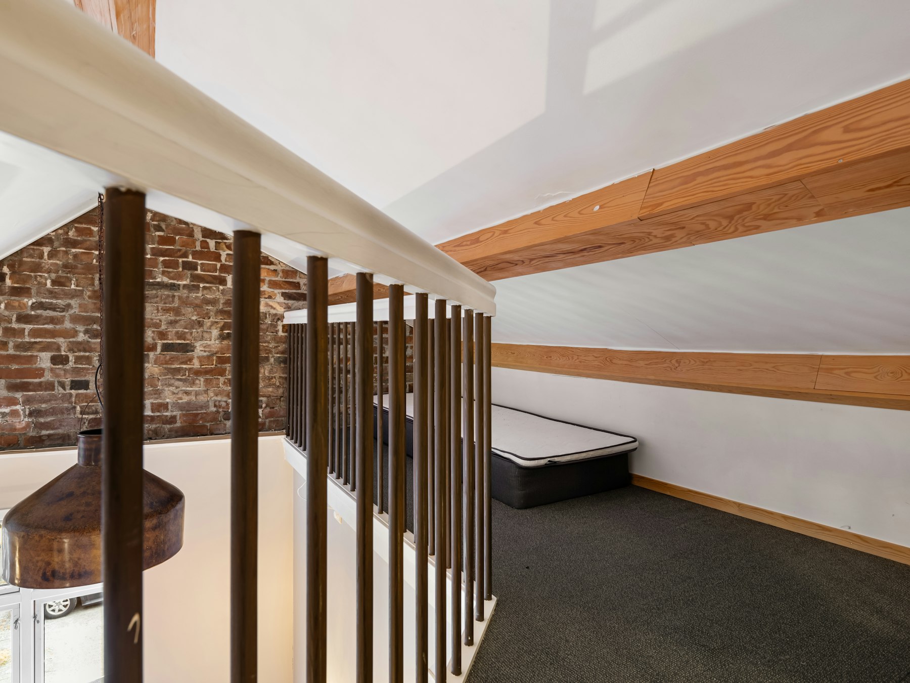 A room with a bed and a brick wall